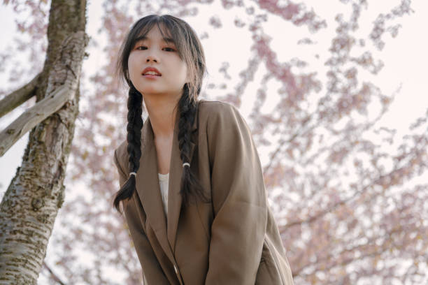 istock Young asian girl under cherry tree 1371174641