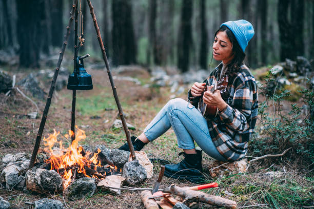 istock Young Woman Playing Guitar by the Campfire 1371175479