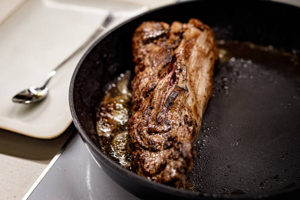 istock A piece of beef is fried in a pan. 1371175559