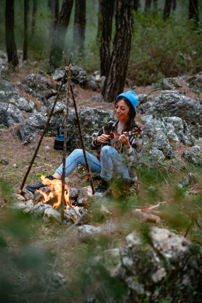 istock Young Woman Playing Guitar by the Campfire 1371176255