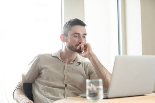 istock Young man with laptop in a room looking pleased 1371178703