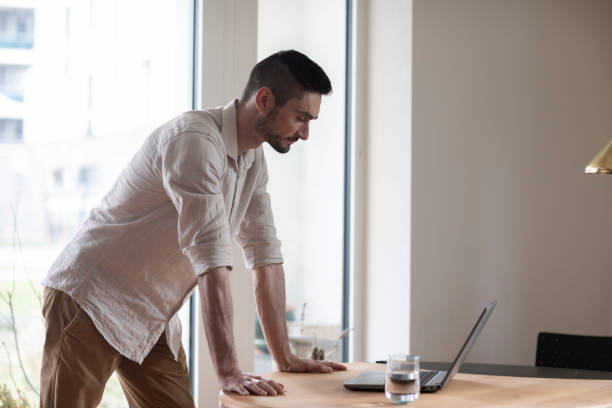 istock Young man with laptop in a room looking pleased 1371178713