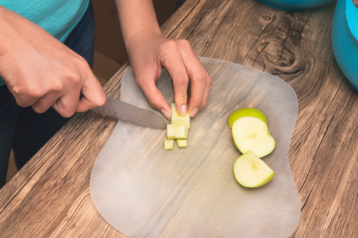 closeup of hands on latin girl cutting green apples