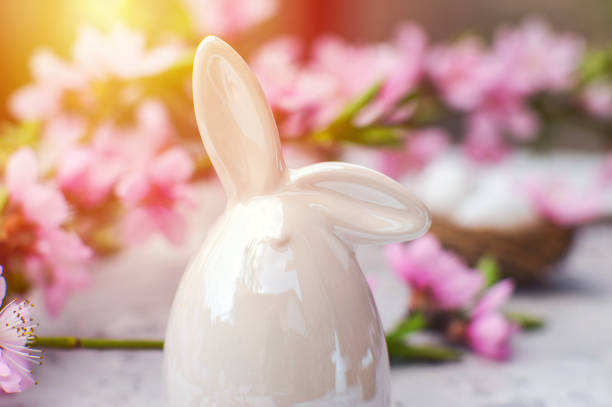 istock Spring blossom, Easter concept, miniature bunny, flowering tree close-up and copy space. Pink natural texture of natural flowering tree. Easter egg and branches of blossoming on an table.. 1371179618