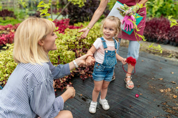 bambina che impara a conoscere il giardinaggio botanico da sua madre e sua nonna - casual granddaughter farmer expressing positivity foto e immagini stock