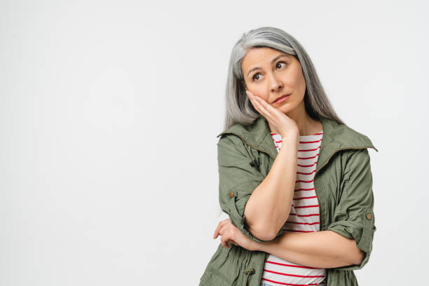 sad bored tired caucasian mature middle-aged woman in casual clothes feeling exhausted offended in bad mood isolated in white background. toothache - dull colors imagens e fotografias de stock