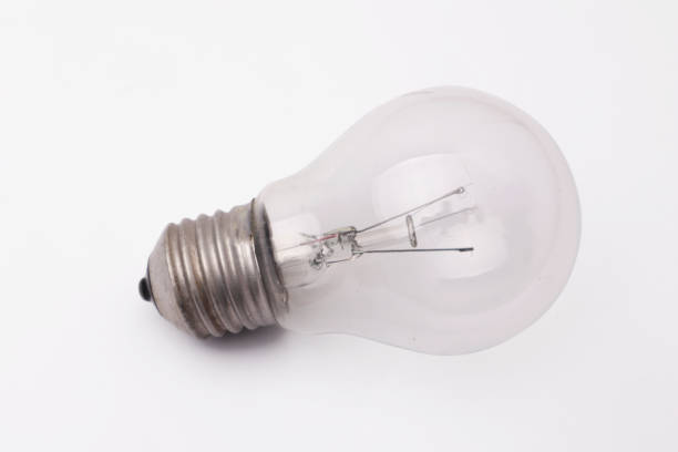 istock Vintage filament lamp light bulb laying on white table 1371183465