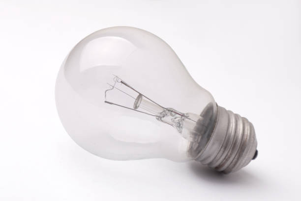 istock Vintage filament lamp light bulb laying on white table 1371183477