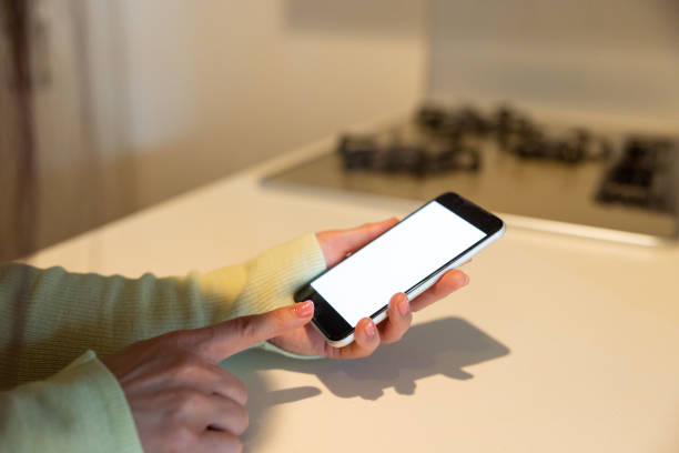 istock Woman ordering something and making reservation through smart phone app in kitchen 1371186107