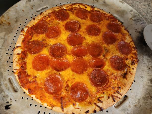 istock pepperoni pizza with melted cheese on metal baking tray 1371188272