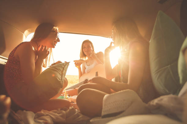 istock Three best friends having fun in the car trunk while making a road trip 1371189793