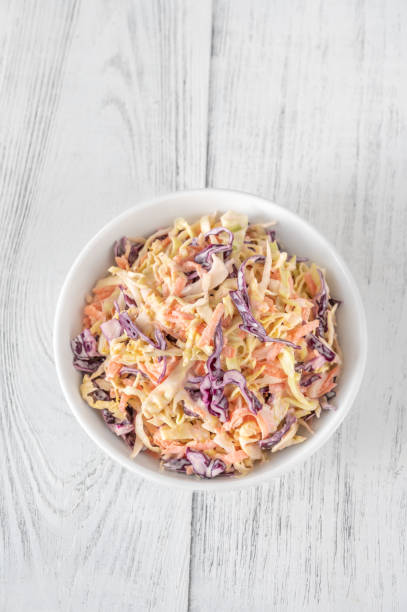 Bowl of Coleslaw salad Bowl of Coleslaw salad on wooden table coleslaw stock pictures, royalty-free photos & images
