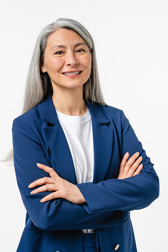 Vertical portrait of confident smiling caucasian middle-aged mature businesswoman ceo manager employee in formal attire with arms crossed looking at camera isolated in white background.