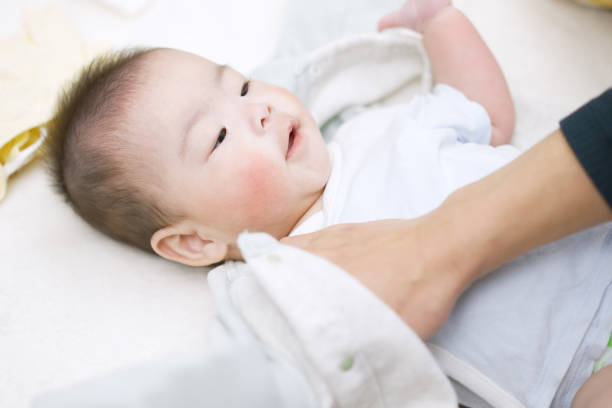 istock Asian dad changing baby clothes 1371192401