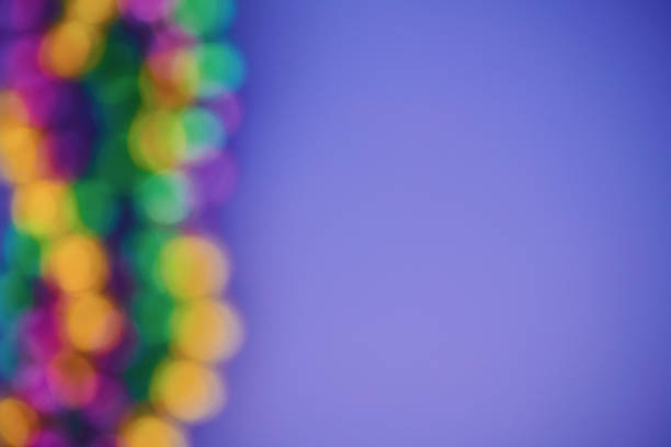 Background for Mardi Gras with defocused vibrant beads on a purple background
