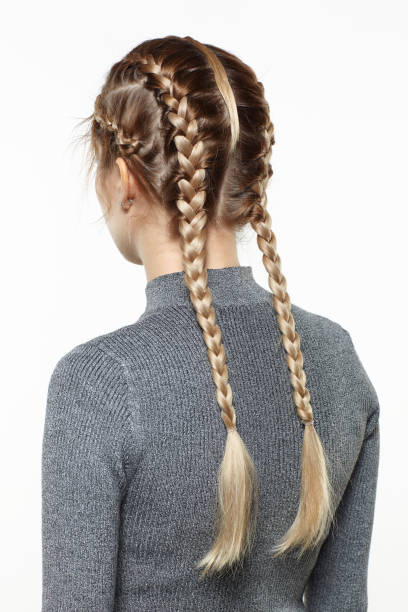 back view portrait of blonde female with creative braid hairdo. stock photo