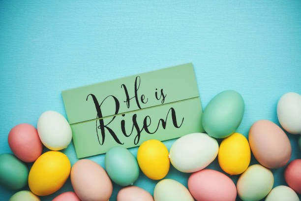 istock He is Risen message on a blue background with collection of pastel colored Easter eggs 1371204417