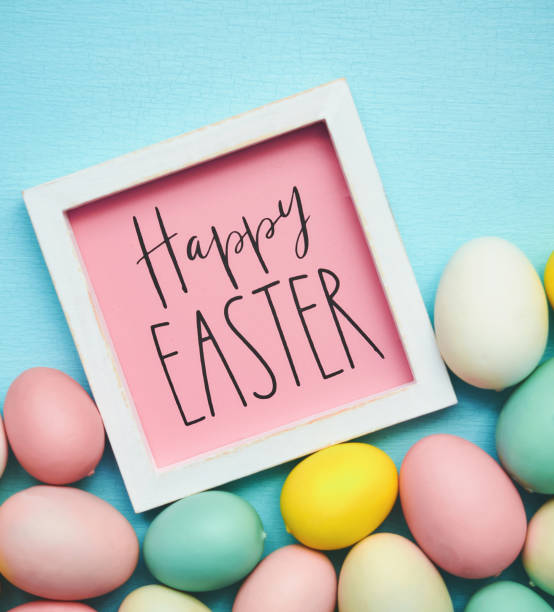 Happy Easter message on a blue background with collection of pastel colored Easter eggs