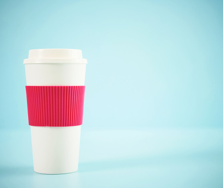 Disposable or reusable plastic coffee cup on a blue background