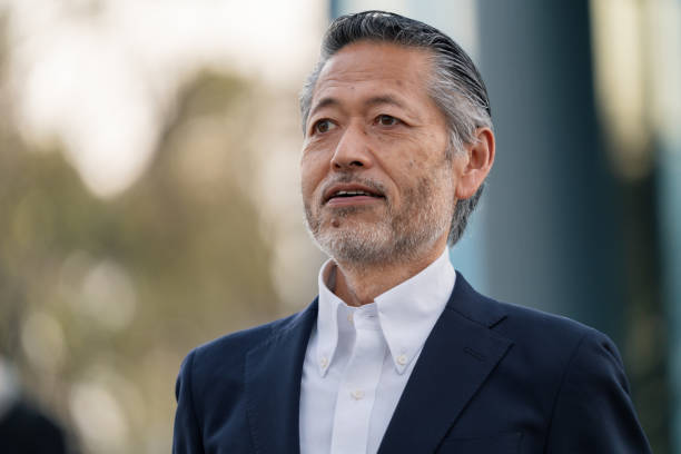 istock Mature grey haired business man in a suit 1371215746