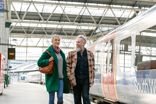 Vibrant senior couple walking on train station platform