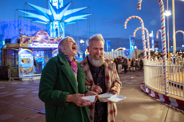 pareja activa de personas mayores divirtiéndose en un carnaval de invierno - senior adult fun autumn senior couple fotografías e imágenes de stock