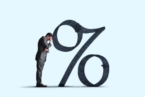 istock Man Leans Head Against Large Interest Rate Symbol 1371218463