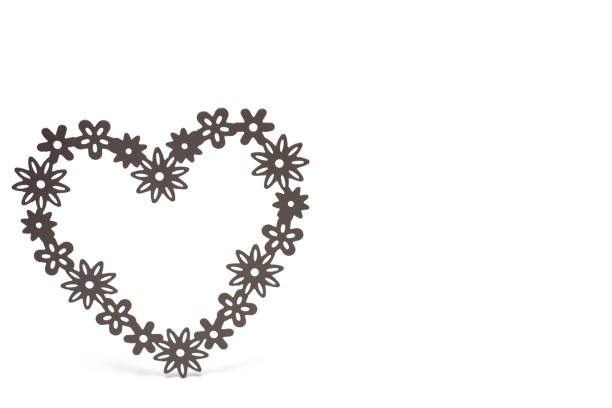 Close up of heart made of filigree shapes on white background as wedding love and valentines day concept