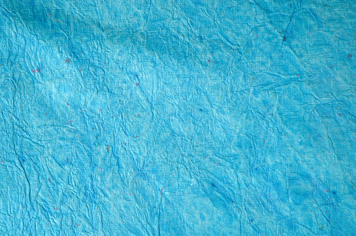 Grunge effect faded crumpled creased vibrant turquoise blue backgrounds - suitable to use as wallpaper, greeting cards or posters backdrops and templates. There is No people and No text. There is copy space for text.