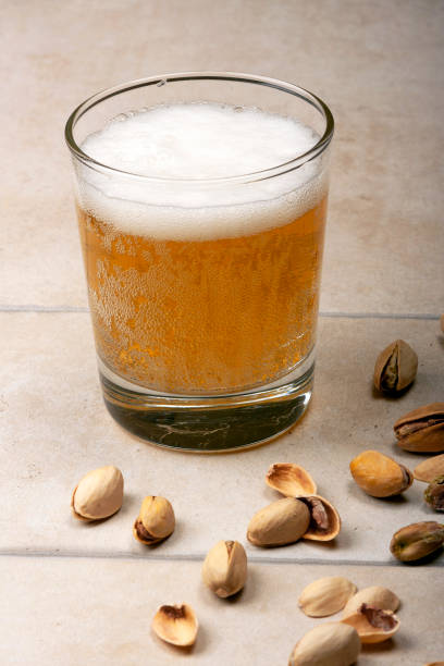 A glass of beer and pistachios stock photo