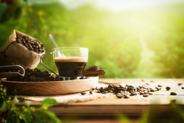 istock Cup of coffee and beans on table in crop field 1371232383
