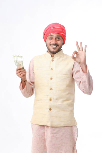 giovane contadino indiano che mostra denaro su sfondo bianco. - smiling human settlement traditional culture man made object foto e immagini stock