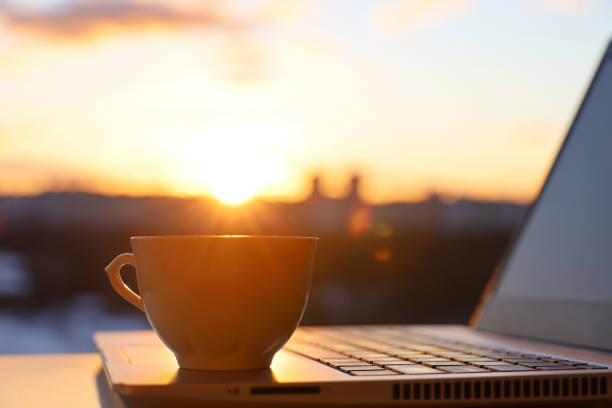 istock Coffee cup and laptop on table against the window with sunshine 1371232604