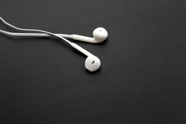istock White earphones on dark background. 1371235896