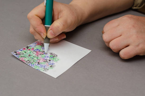 istock A woman's manicure-less hand draws an abstract drawing with a pen. 1371239429