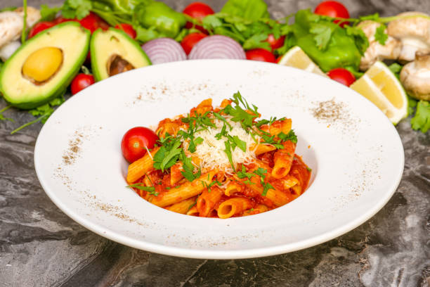 penne pasta in tomatensauce, tomaten mit petersilie auf holzhintergrund verziert - penne rigatoni pasta tomato pasta stock-fotos und bilder