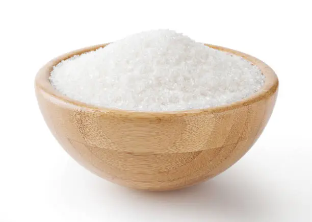 Photo of Granulated white sugar in wooden bowl isolated on white background with clipping path