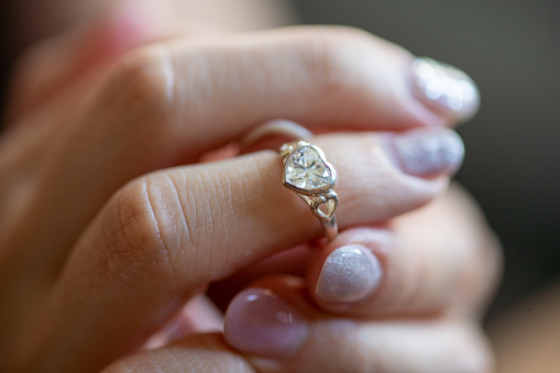 Close-up shot of a Asian woman put on a heart shape diamond ring on her finger