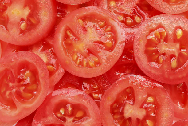 istock Background of sliced red ripe tomatoes. Top view. 1371246784