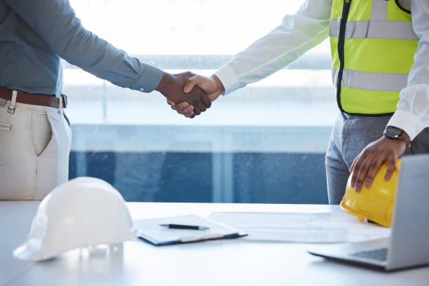 foto de dos constructores dándose la mano de acuerdo - hardhat construction men handshake fotografías e imágenes de stock