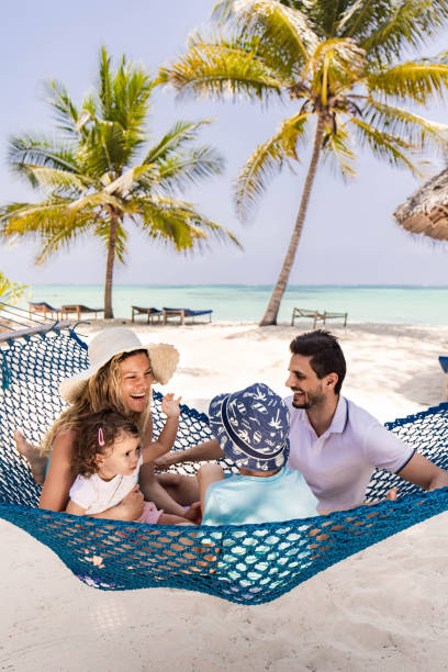 istock Cheerful family talking in hammock on the beach. 1371256918