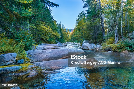 istock Huge smooth boulders honed by ancient glaciers and flows of the Ammonoosuk mountain river near a waterfall in the foothills of Mount Washington in the White Mountain National Forest 1371257026