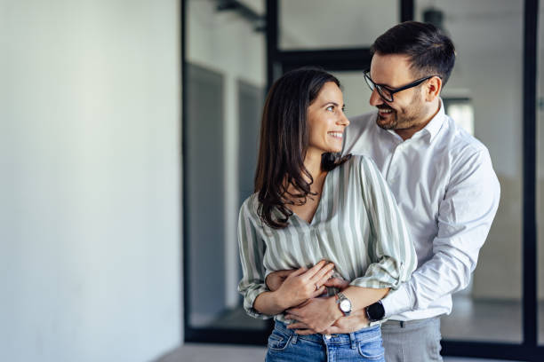 istock Confident caucasian man, hugging his female parnter from behind. 1371257630