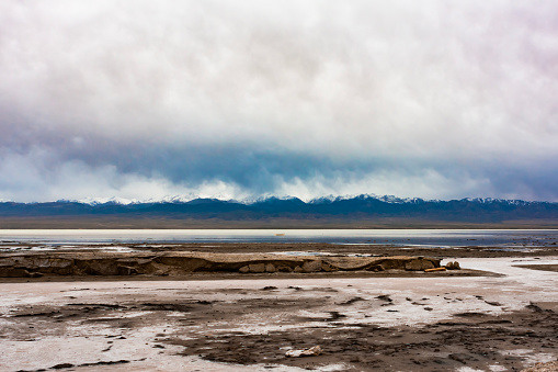 A small boat on Chaka Salt Lake, Qinghai Province, China, with snow-capped mountains in the distance