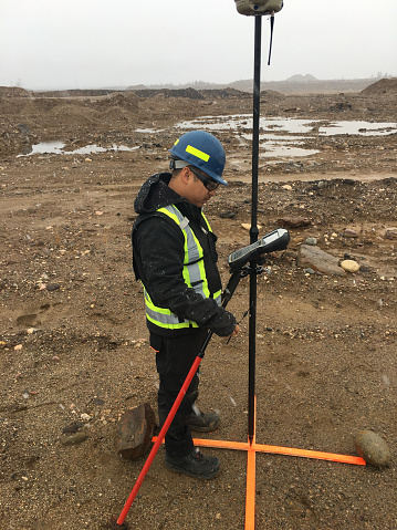 Land surveyor working at a mine site in Fort McMurray, Alberta