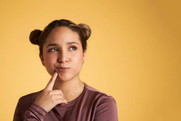 Young woman touching chin and looking at camera