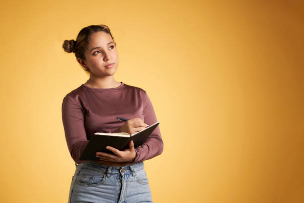 istock Thoughtful woman with clipboard in studio 1371261420