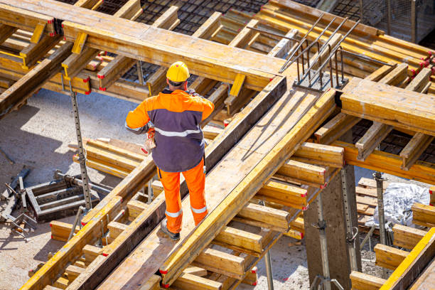 Construction worker at a construction site A construction worker is installing the formwork on the construction site. CONCRETE FORMWORK concrete in formwork stock pictures, royalty-free photos & images