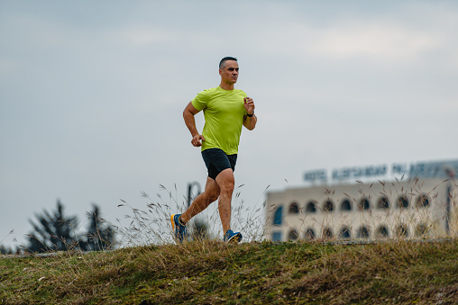 Fit athletic mature runner during a running exercise outdoors