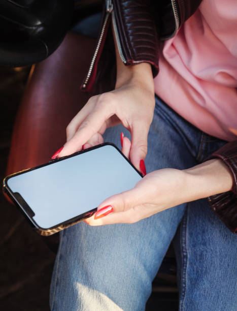 istock Woman using a blank screen smart phone on a car 1371266240